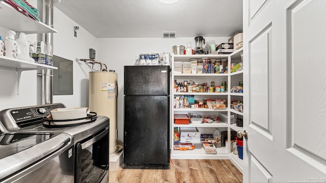 interior space featuring electric panel, water heater, and washer and dryer