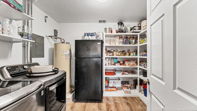 pantry featuring electric panel, visible vents, washer and dryer, and electric water heater