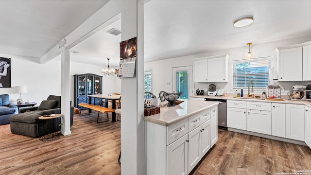 kitchen with sink, hardwood / wood-style flooring, white cabinetry, and dishwasher