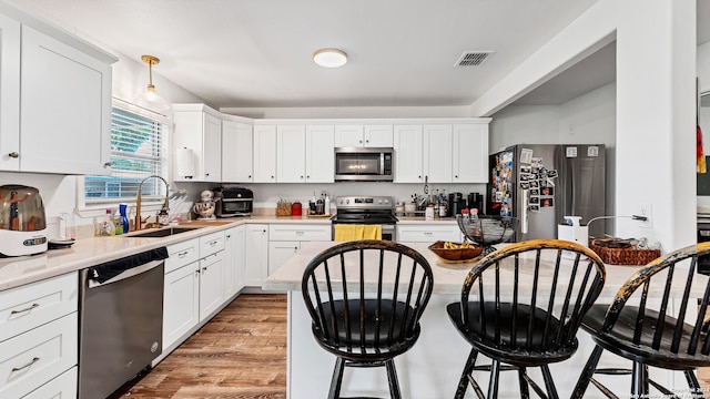 kitchen featuring light hardwood / wood-style floors, sink, stainless steel appliances, and white cabinets