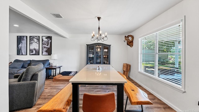 dining room with visible vents, an inviting chandelier, wood finished floors, beamed ceiling, and baseboards