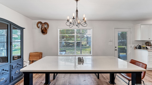 dining area with a healthy amount of sunlight, an inviting chandelier, and light wood-type flooring