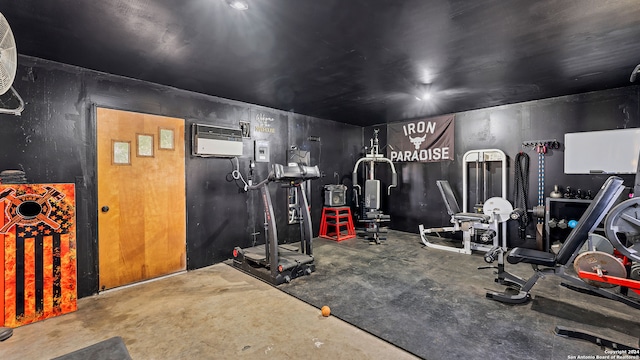 workout area with concrete floors and an AC wall unit