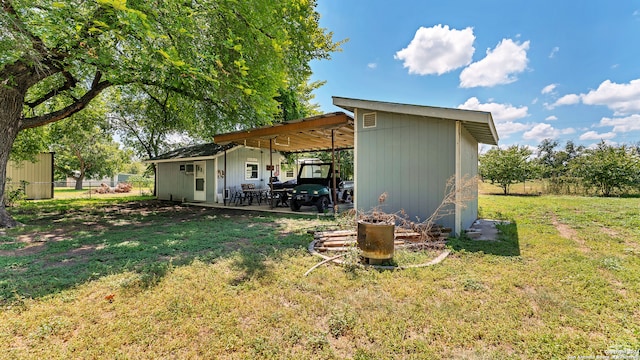 back of property featuring a yard and an outbuilding