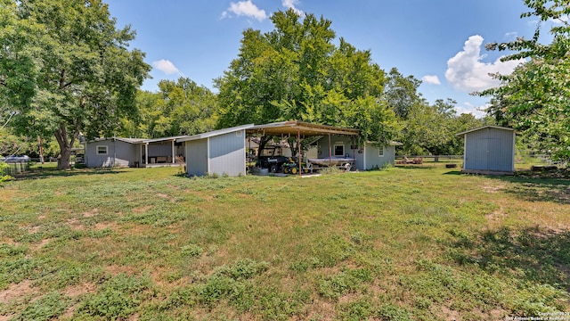 view of yard with a carport and a storage unit