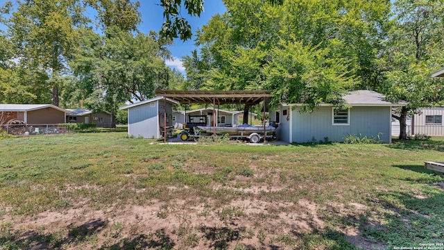 rear view of house with a lawn and a carport