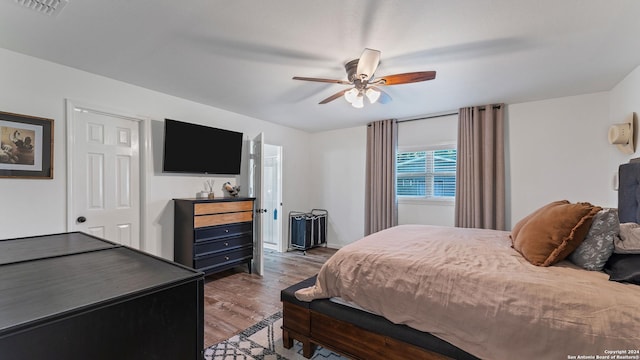 bedroom with visible vents, ceiling fan, and wood finished floors