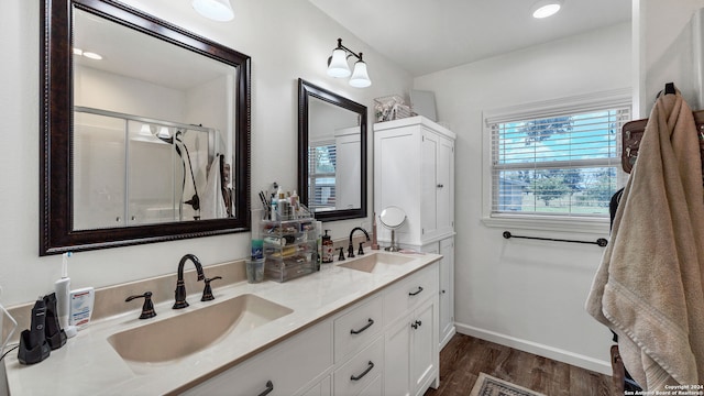 bathroom featuring dual vanity, wood-type flooring, and a shower with shower door