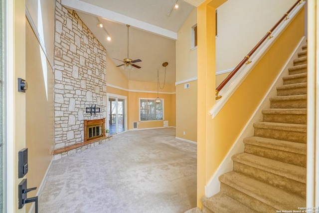 unfurnished living room featuring high vaulted ceiling, ceiling fan, carpet floors, and a fireplace