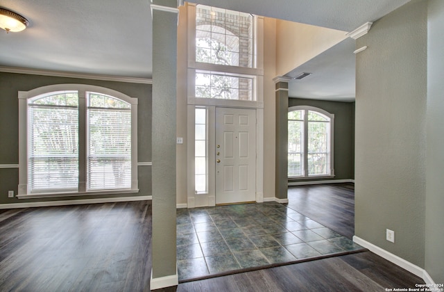 foyer featuring ornamental molding and dark hardwood / wood-style floors