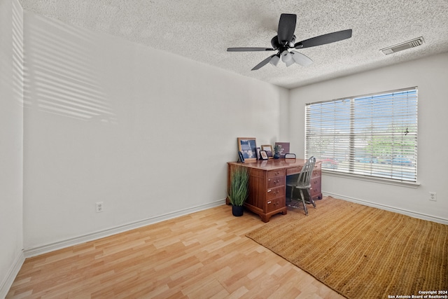 office featuring a textured ceiling, ceiling fan, and light wood-type flooring