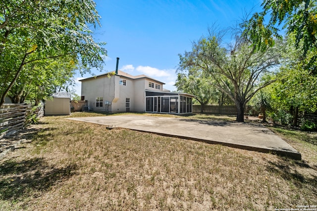 view of yard with a patio area, a sunroom, and a storage shed