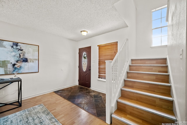 entryway featuring wood-type flooring and a textured ceiling