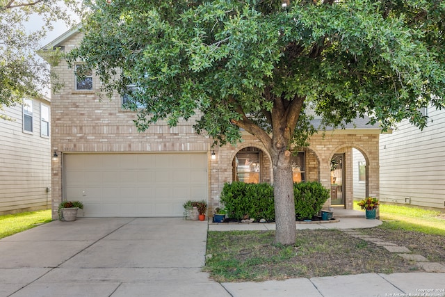 view of property hidden behind natural elements with a garage