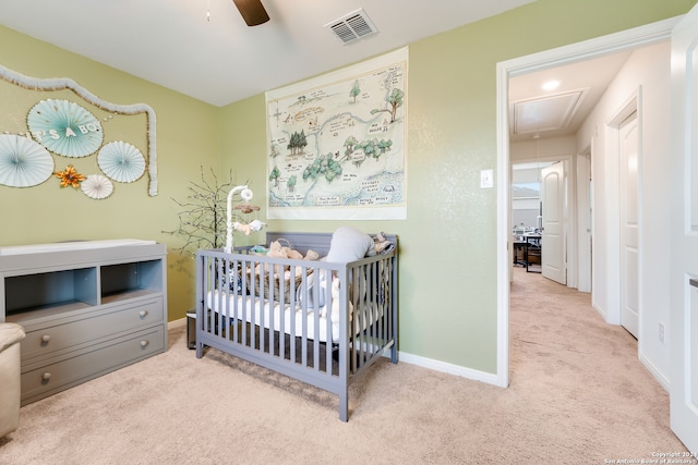 bedroom with ceiling fan, light carpet, and a crib