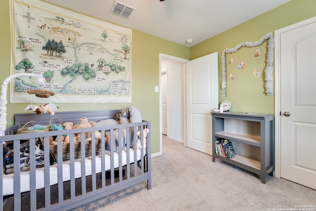 carpeted bedroom featuring a nursery area