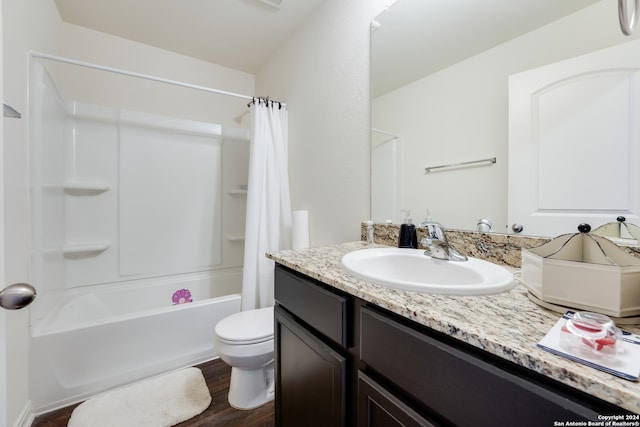 full bathroom with hardwood / wood-style flooring, toilet, shower / bath combo with shower curtain, and vanity