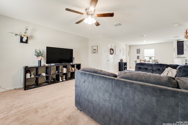 carpeted living room with ceiling fan