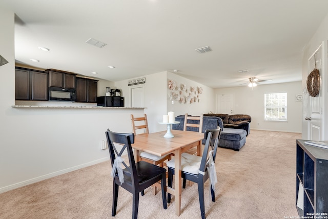 carpeted dining space featuring ceiling fan