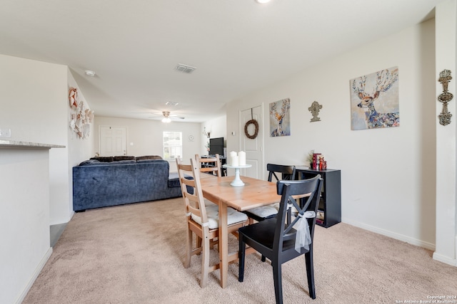 carpeted dining room featuring ceiling fan