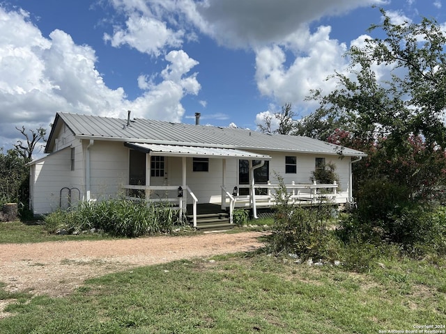 rear view of property featuring a lawn