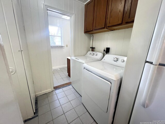 laundry area featuring cabinets, independent washer and dryer, and light tile patterned floors