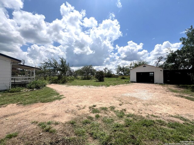 view of yard featuring an outdoor structure and a garage