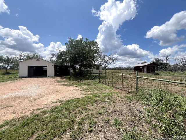 view of yard featuring a rural view and an outbuilding