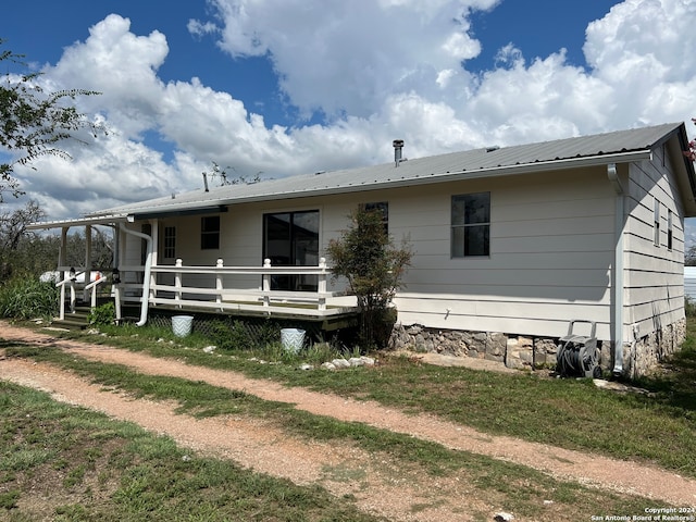 rear view of property featuring a wooden deck