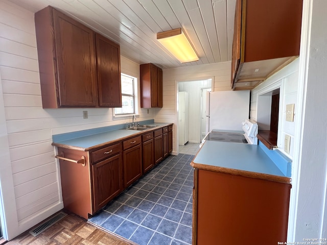 kitchen with sink, range, white fridge, and dark parquet floors