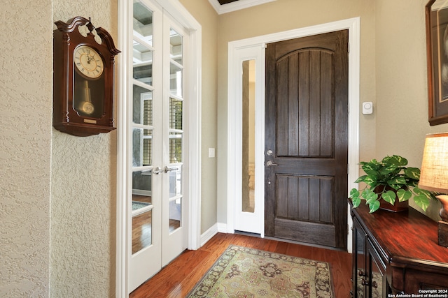 entryway with crown molding, hardwood / wood-style flooring, and french doors