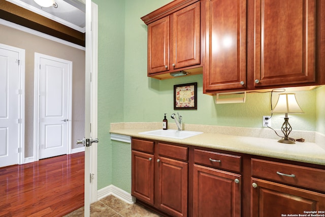 kitchen featuring sink, light hardwood / wood-style flooring, and crown molding