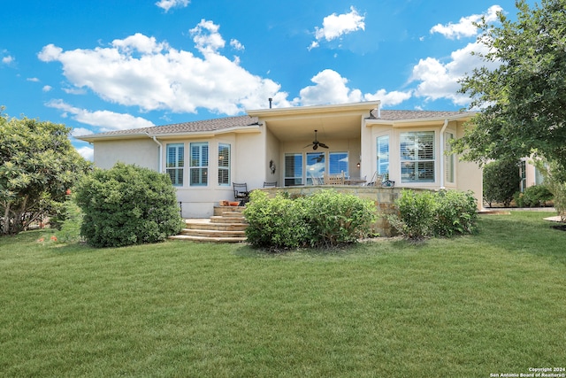 back of house featuring a lawn and ceiling fan