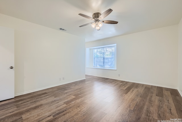 empty room with ceiling fan and dark wood-type flooring