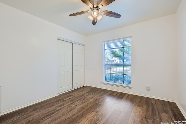 unfurnished bedroom with ceiling fan, dark hardwood / wood-style floors, and a closet