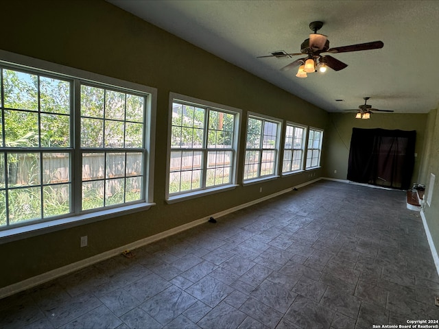 tiled empty room featuring ceiling fan and vaulted ceiling