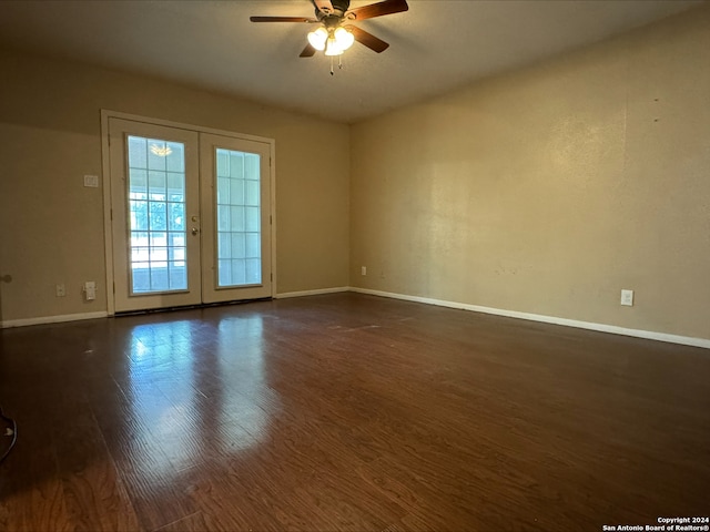 empty room with ceiling fan, dark hardwood / wood-style flooring, and french doors