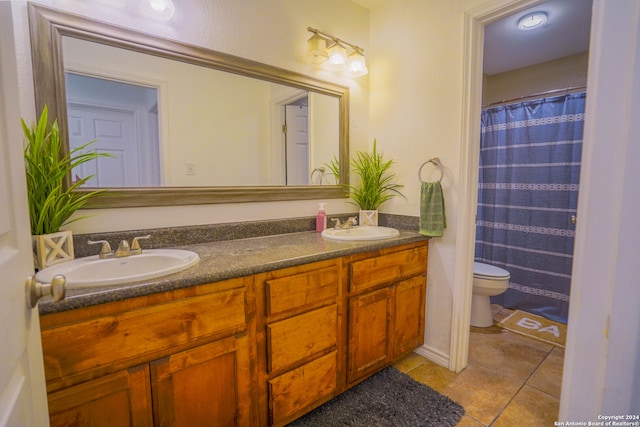 bathroom with dual vanity, toilet, and tile patterned floors