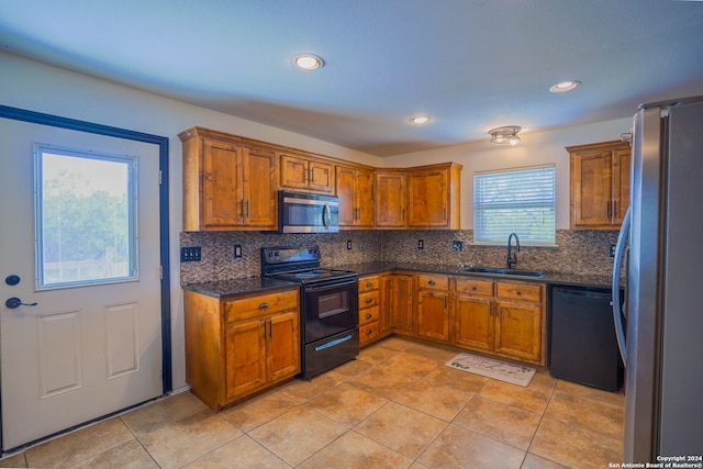 kitchen featuring light tile patterned flooring, sink, tasteful backsplash, and black appliances