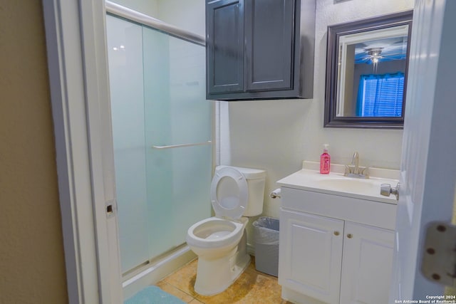 bathroom featuring toilet, walk in shower, tile patterned flooring, and vanity