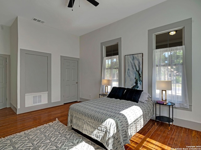 bedroom with multiple windows, ceiling fan, and wood-type flooring