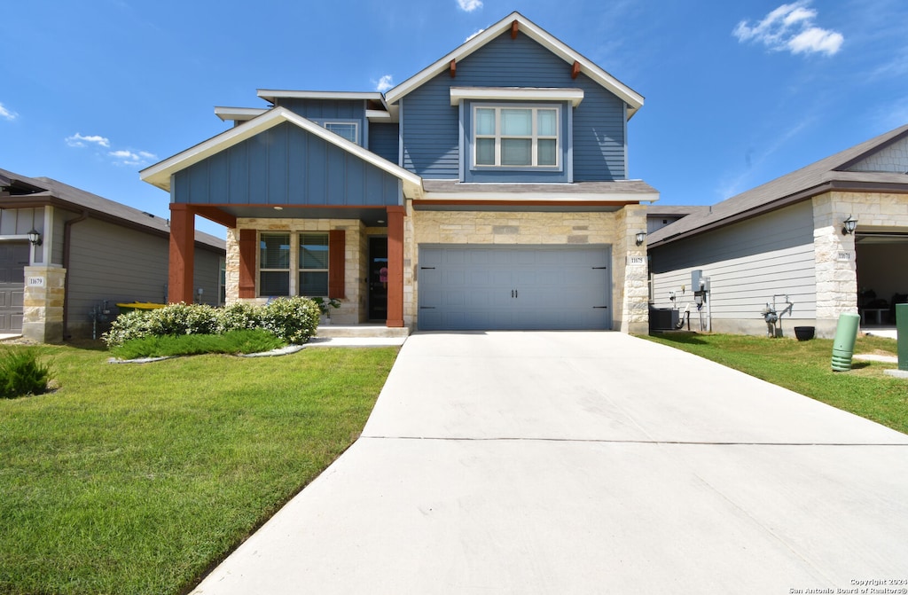 craftsman house featuring cooling unit, a garage, and a front yard