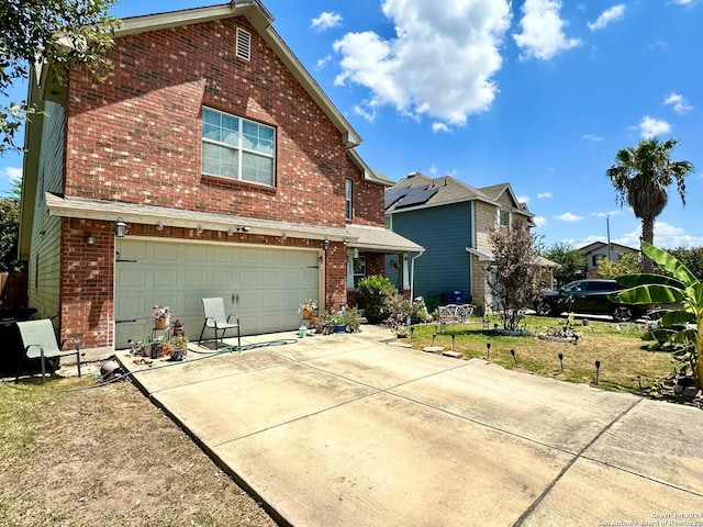 view of front property featuring solar panels, a garage, and a front yard