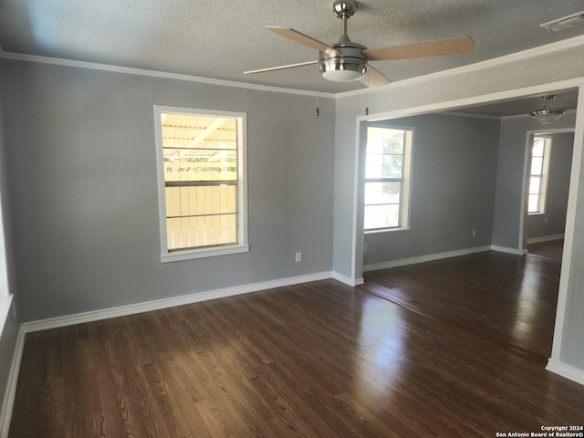 empty room with baseboards, visible vents, dark wood finished floors, a textured ceiling, and crown molding