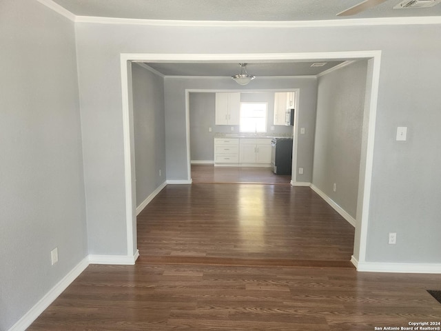 unfurnished dining area featuring ornamental molding, dark wood-style flooring, visible vents, and baseboards