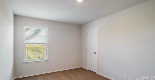 carpeted spare room featuring a healthy amount of sunlight