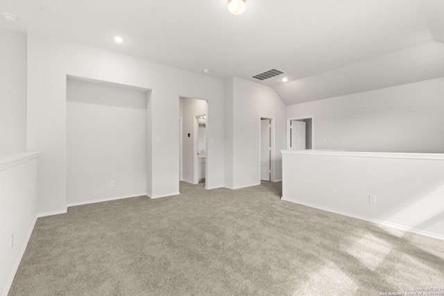 carpeted empty room featuring lofted ceiling