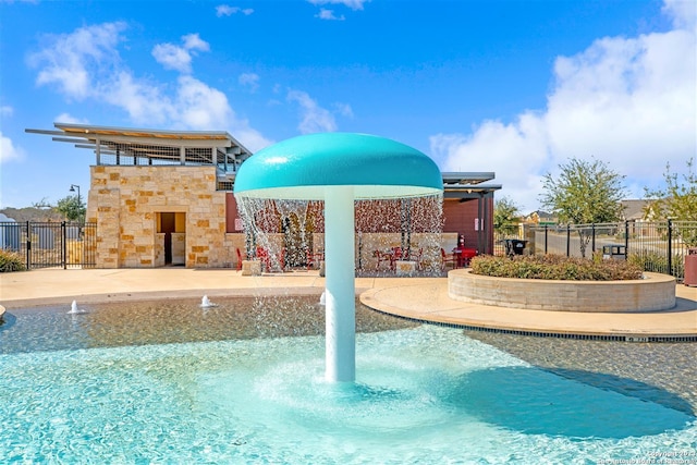 view of swimming pool with pool water feature and a patio area