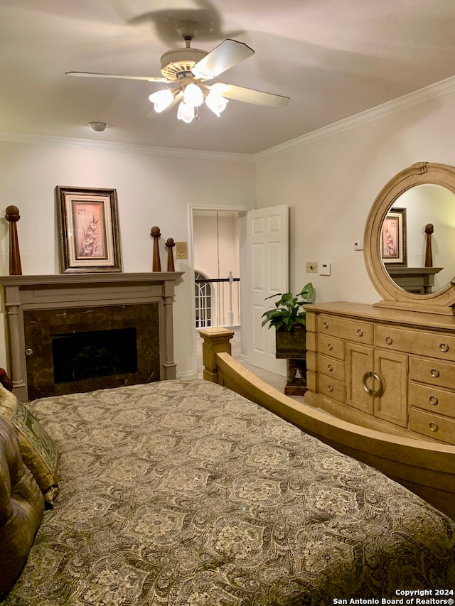 bedroom featuring ceiling fan, ornamental molding, and a premium fireplace