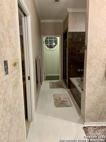 bathroom with crown molding and tile patterned flooring